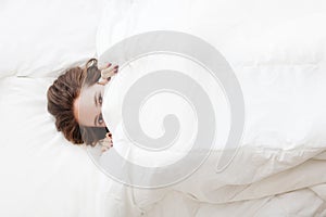 Woman in bed under the blanket