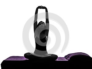 Woman in bed waking up stretching arms silhouette