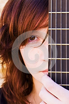 Woman behind guitar fretboard