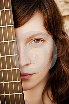 Woman behind guitar fretboard