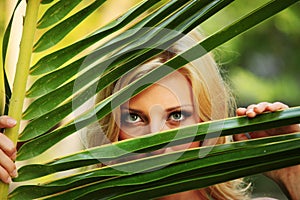 Woman behind the palm leaves