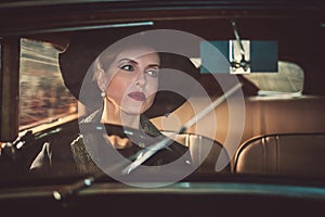 Woman behind steering wheel of a retro car