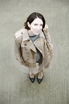Woman at beige coat and gray square concrete