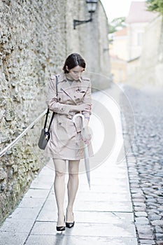 Woman at beige coat look at pale hand