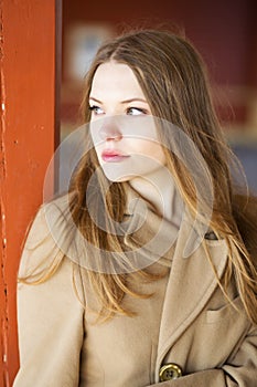 Woman in beige coat with sad face