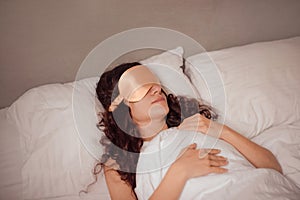 woman in beige silk sleep mask rest in bed at home. deeper and more restful sleep by blocking out any unwanted light