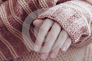 Woman in a beige soft warm sweater folded her hands