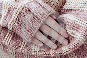 Woman in a beige soft warm sweater folded her hands