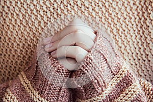 Woman in a beige soft warm sweater hold hands together is symbol prayer and gratitude