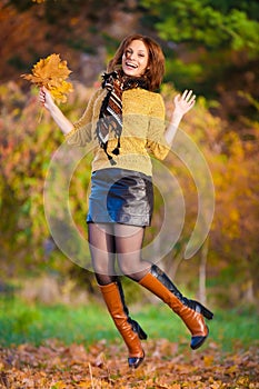 Woman in beige sweater and black leather skirt jump