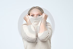 Woman being childish disappearing in her clothes looking from underneath. She is frightened with exam results.