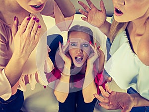 Woman being gossiped by two