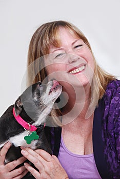 Woman being kissed by dog