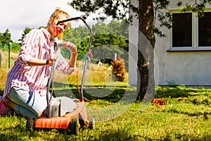 Woman being mowing lawn with lawnmower