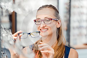 Woman being satisfied with the new eyeglasses she bought in the store