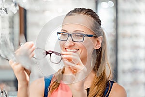Woman being satisfied with the new eyeglasses she bought in the store