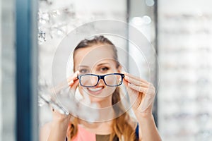 Woman being satisfied with the new eyeglasses she bought in the store