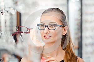 Woman being satisfied with the new eyeglasses she bought in the store