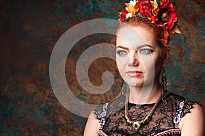 Woman in belly dance costume with black lace in red circlet of flowers looking away