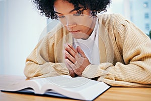 Woman, bible and prayer at desk, religion and Christian worship in home at table. Person, holy book and meditation for