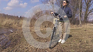 Woman with bicycle arrives at the lake