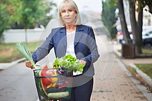 Woman with bicycle basket full of groceries