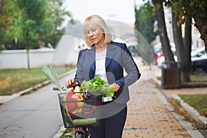 Woman with bicycle basket full of groceries