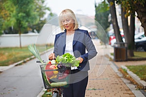 Woman with bicycle basket full of groceries