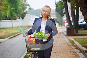 Woman with bicycle basket full of groceries