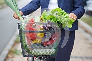 Woman with bicycle basket full of groceries