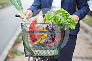 Woman with bicycle basket full of groceries