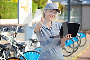 woman bicycle mechanic repairing bike with pc outdoors