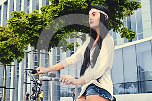 A woman on a bicycle over modern building background.