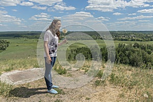 Woman with big dandelion on sky background. Copy space. Summer concept.