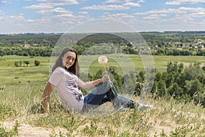 Woman with big dandelion on sky background. Copy space. Summer concept.