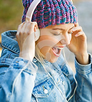 Woman with big headphone. Girl listens to music in headphones. Smiling girl relaxing, music a smartphone and headphones