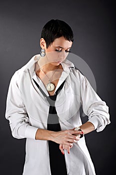 Woman in big man shirt looking in watch