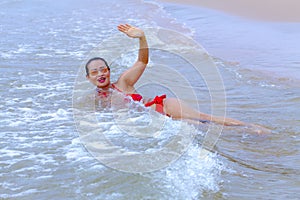 Woman big shape with red bikini r enjoy wave on beach