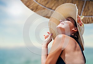 Woman in big straw hat enjoyed with summer sun photo