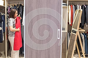 Woman in big walkin closet choosing clothes. modern wardrobe and dressing room with copy space