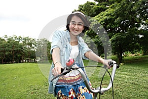 Woman with a bike outdoors smiling