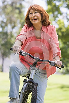 Woman on bike outdoors smiling