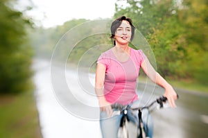 Woman with bike on the rainy forest