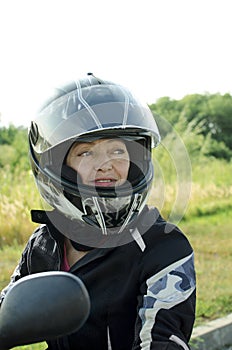 Woman biker in a safety helmet and special protective clothing for riding a motorcycle