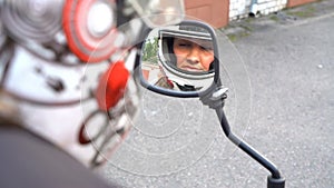 Woman biker young rider looking at motorcycle mirror fixing helmet prepare for journey