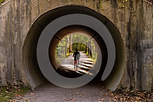 Woman Bikes Through Tunnel on Towpath