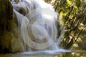 Woman with bikini black enjoy water at Erawan Waterfall