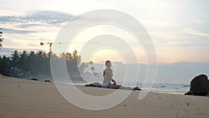 Woman in bikini engages in yoga session on sandy beach