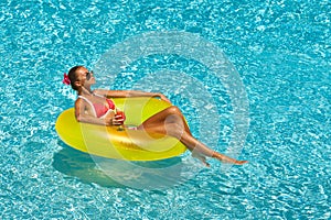 woman in bikini enjoying summer sun and tanning during holidays in pool