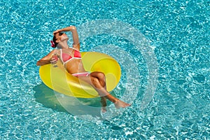 woman in bikini enjoying summer sun and tanning during holidays in pool